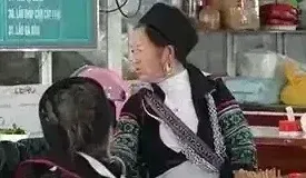 Hmong women in traditional indigo dress sharing a hot meal at a local food court inside Sapa Market in northern Vietnam