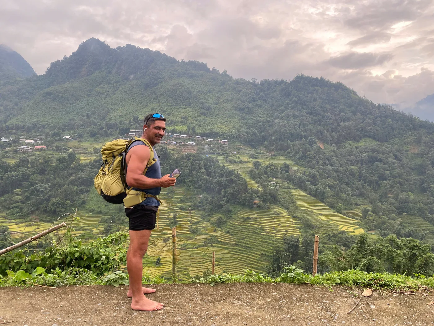 Person with a large backpack standing above terraced hills
