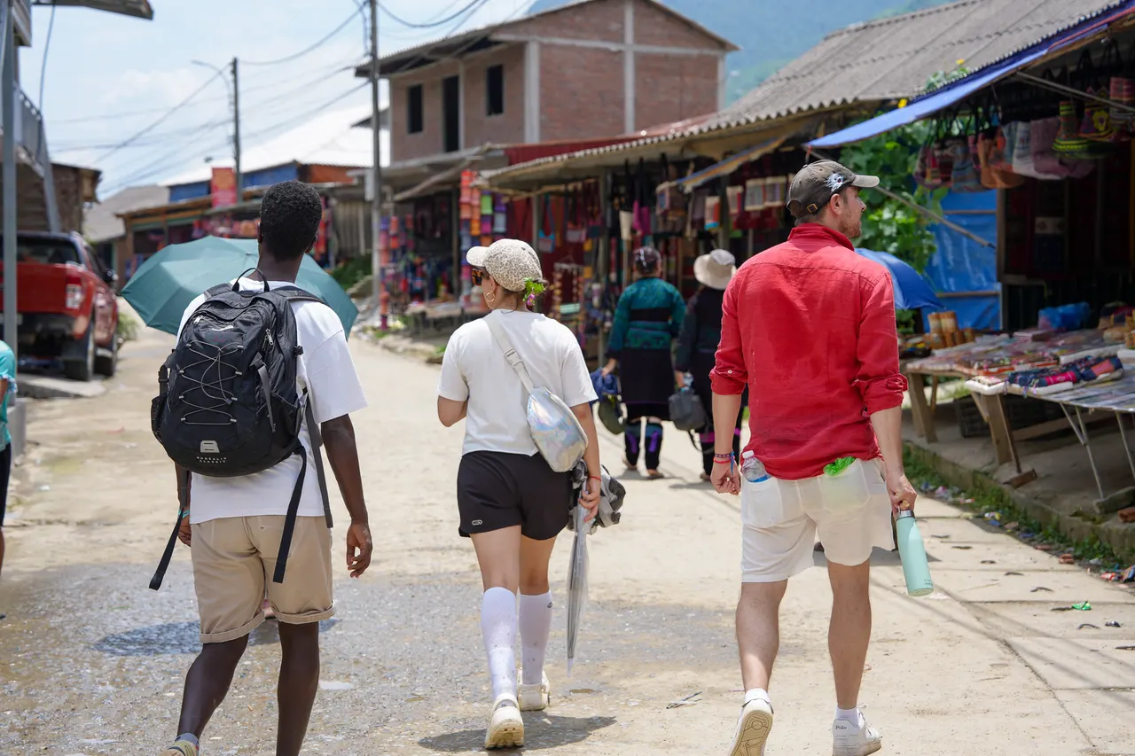 Travellers walking a village path above the Sapa valley