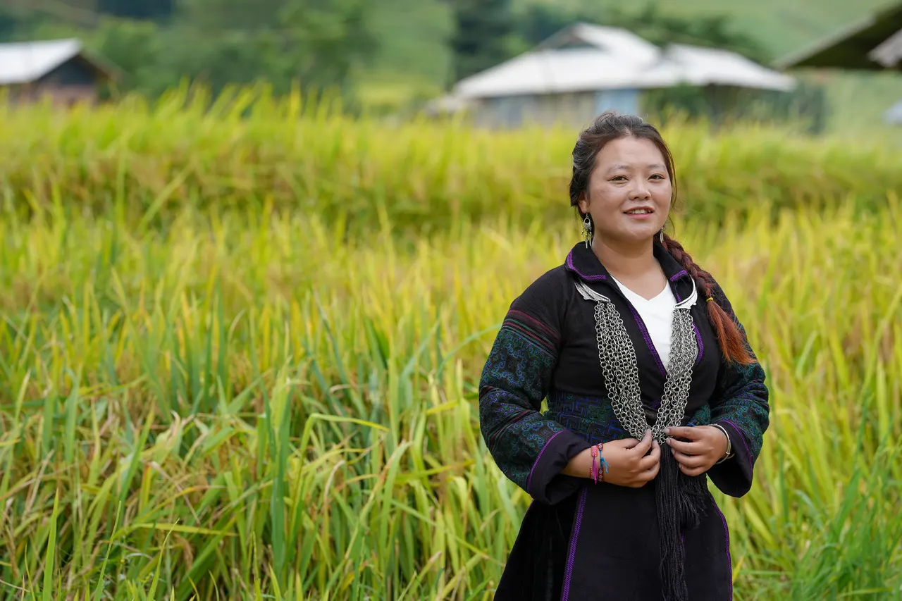 Local guide in traditional dress with silver jewellery among Sapa rice terraces