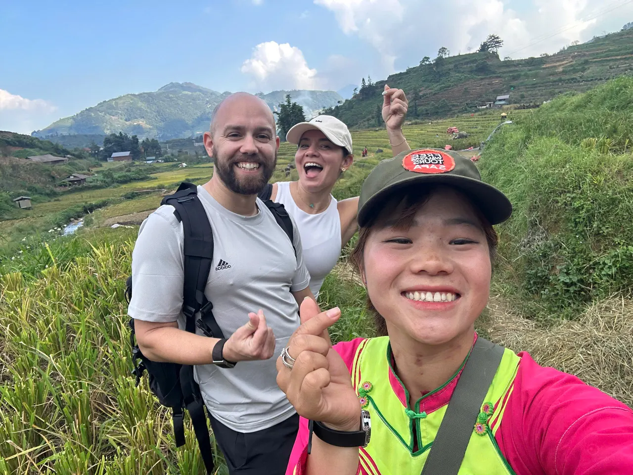 Local guide and guests smiling together on a terrace trail in Sapa